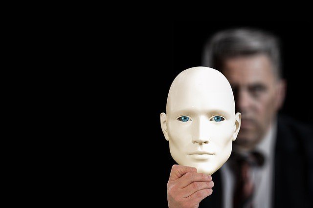 Businessman partially hiding behind a mask